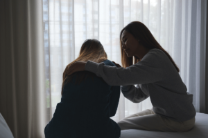 Woman comforts friend after learning how to help a loved one with depression