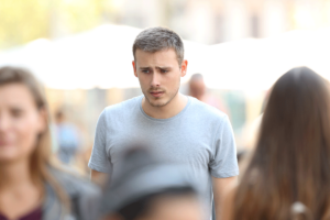 Man looks around crowd as he struggles with social anxiety