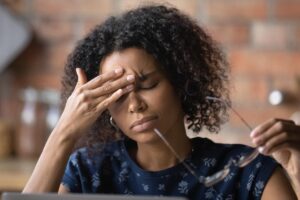 Woman puts hand on head, wondering how trauma affects the brain