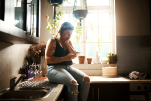 Woman sits and looks at phone as she thinks about compulsive behaviors