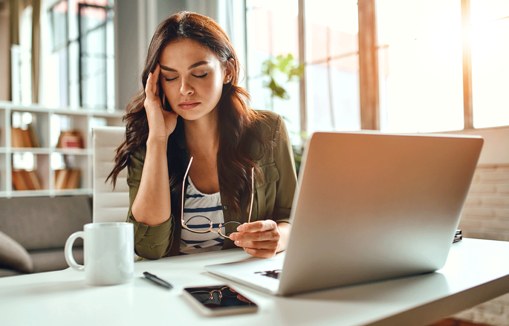 Woman sits at computer as she struggles with ADHD paralysis