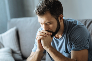 Man sits on couch as he struggles to manage the manic phase of bipolar disorder