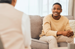 Man sits on couch and talks to therapist during psychiatry in Seattle, WA