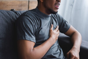 Man grabs at his heart wondering if he is having an anxiety attack or a panic attack