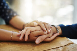 Woman holds hands with loved one who is living with major depressive disorder