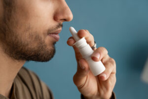 Person holding Spravato nasal spray to their nose