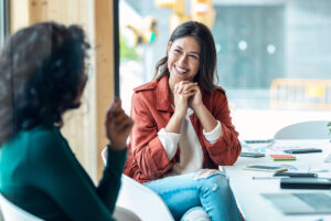 a smiling woman talks to another woman about how she manages her social anxiety disorder