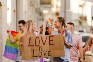 Young lesbian couple walking with placard during pride parade